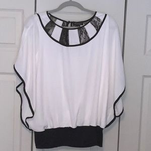 Thalia Sodi flow off white blouse with black trim. A single button closure.